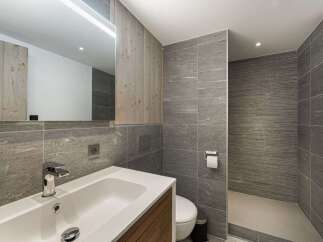Step into a modern bathroom oasis, featuring sleek gray tile and natural wood accents.