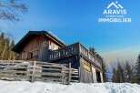 Discover a charming wooden cabin nestled in a snowy landscape, perfect for a serene getaway.