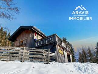 Discover a charming wooden cabin nestled in a snowy landscape, perfect for a serene getaway.