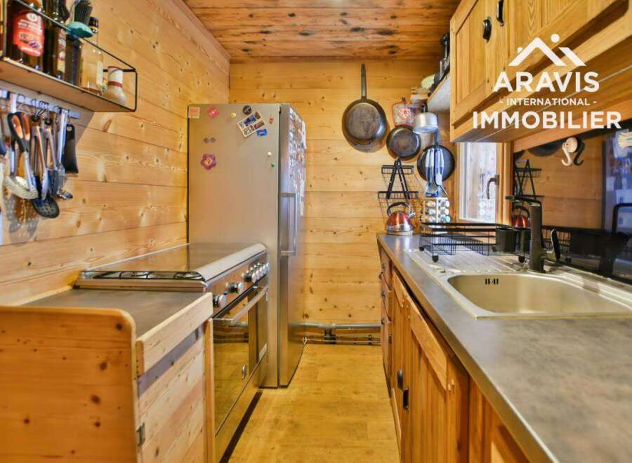 Discover the charm of this cozy kitchen, featuring a stainless steel refrigerator and a modern stovetop.
