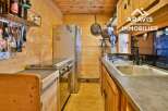 Discover the charm of this cozy kitchen, featuring a stainless steel refrigerator and a modern stovetop.