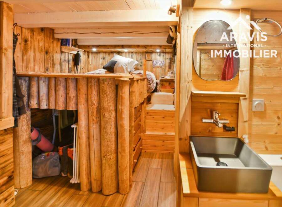 Discover the charm of this unique property featuring rustic wooden interiors and a cozy loft bed.