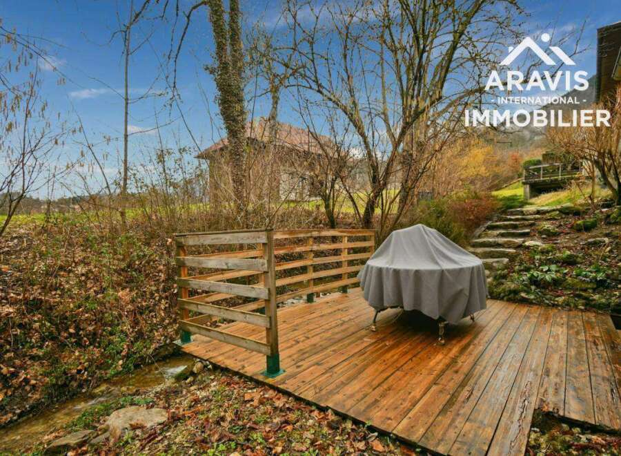Discover a charming property with a wooden deck overlooking a serene stream.
