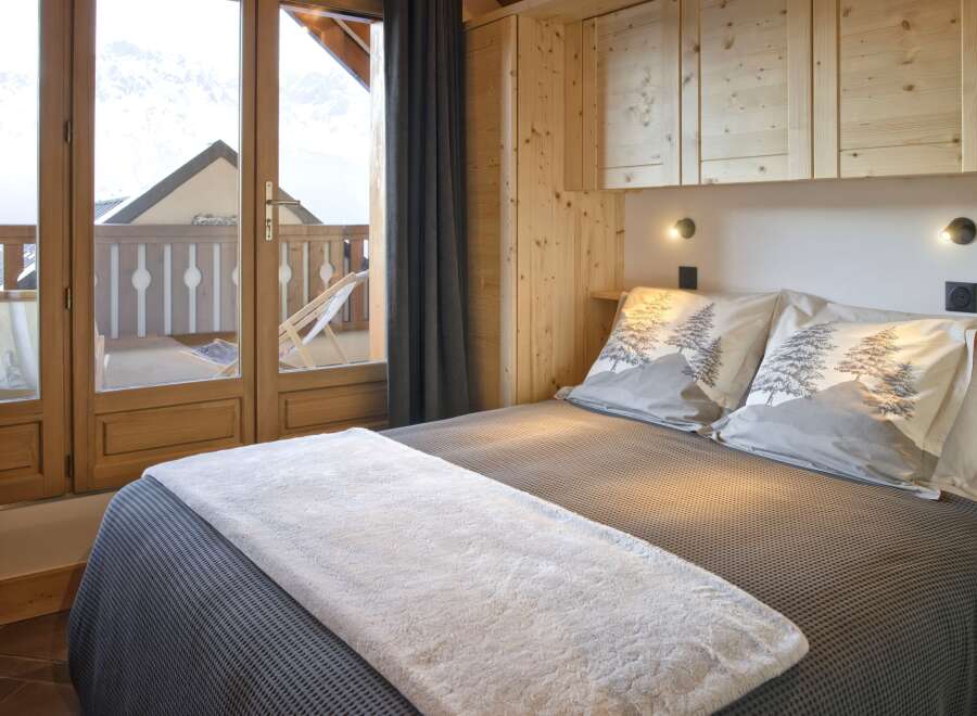 Experience the charm of this cozy bedroom, featuring a comfortable bed with stylish bedding and pillows.