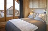 Experience the charm of this cozy bedroom, featuring a comfortable bed with stylish bedding and pillows.