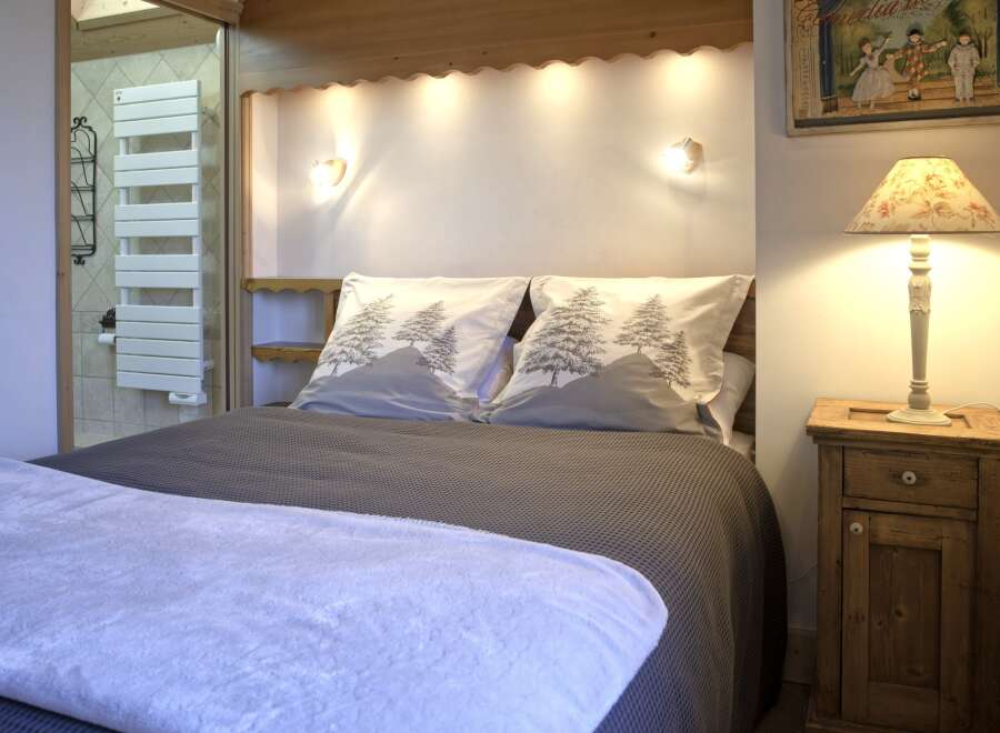 This cozy bedroom features a comfortable bed with stylish bedding, perfect for a relaxing retreat.