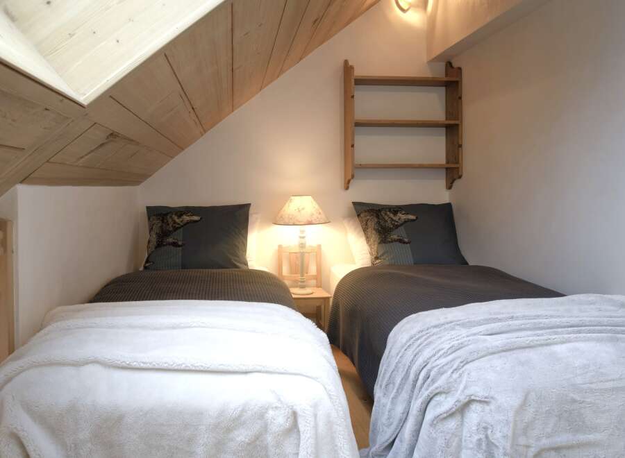 Cozy up in this charming bedroom featuring two twin beds, perfect for guests or a comfortable retreat.
