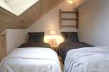 Cozy up in this charming bedroom featuring two twin beds, perfect for guests or a comfortable retreat.