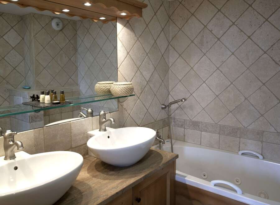 This luxurious bathroom features a double vanity with sleek, modern sinks and faucets.