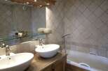This luxurious bathroom features a double vanity with sleek, modern sinks and faucets.