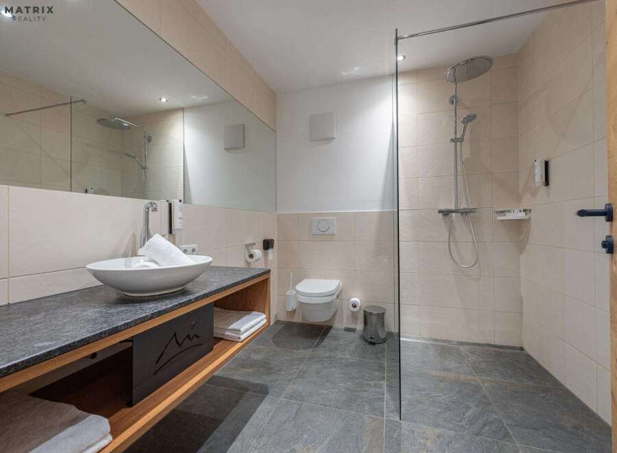 Step into a modern bathroom oasis! This stylish space features a sleek sink, a walk-in shower, and elegant tile work.
