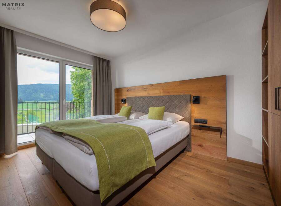 Experience tranquility in this stunning bedroom featuring a comfortable bed and a serene view.