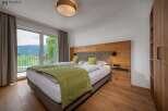 Experience tranquility in this stunning bedroom featuring a comfortable bed and a serene view.