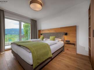 Experience tranquility in this stunning bedroom featuring a comfortable bed and a serene view.