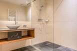 Step into a modern bathroom oasis! This stunning space features a sleek glass-enclosed shower, a stylish floating vanity with a vessel sink, and elegant tile flooring.