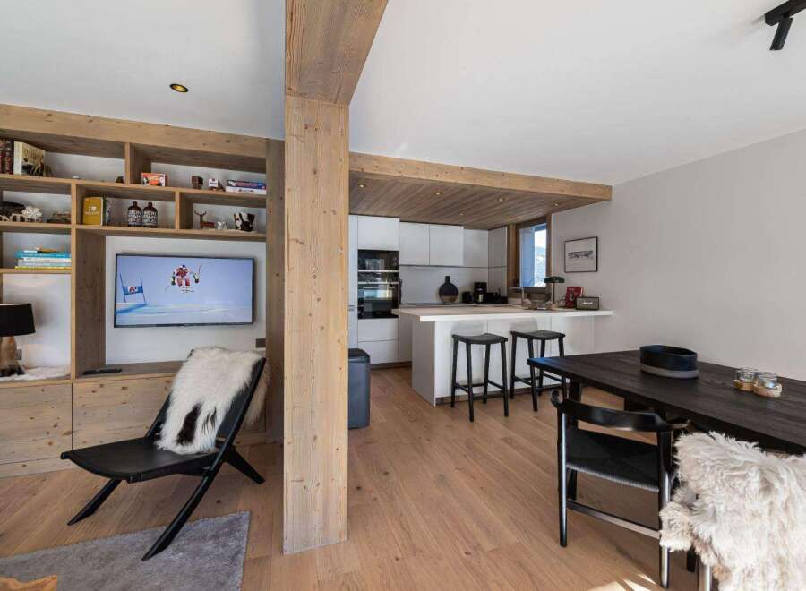 Experience luxury living in this stunning property, featuring a modern kitchen with sleek white cabinetry and a breakfast bar.
