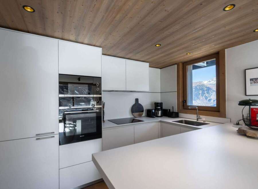 This modern kitchen boasts sleek white cabinetry and a minimalist design, perfect for a contemporary home.