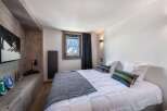 This cozy bedroom offers a serene retreat with its warm wooden accents and inviting ambiance.