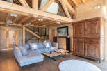 Experience the charm of this stunning property, featuring a cozy living space with a modern gray sofa and a unique wooden ceiling.