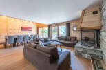 Experience luxury living in this stunning chalet, featuring a spacious living area with a cozy fireplace and comfortable seating.
