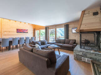 Experience luxury living in this stunning chalet, featuring a spacious living area with a cozy fireplace and comfortable seating.