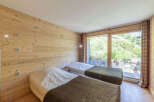 This cozy bedroom features beautiful wooden paneling and two comfortable beds, perfect for a relaxing stay.