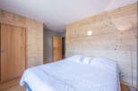 This cozy bedroom features a stunning wooden wall that adds warmth and character to the space.