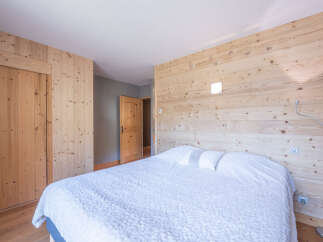 This cozy bedroom features a stunning wooden wall that adds warmth and character to the space.