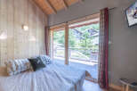 Experience the charm of this cozy bedroom, featuring a stunning view through large windows.
