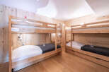 This cozy bedroom features two sets of wooden bunk beds, perfect for accommodating multiple guests or family members.