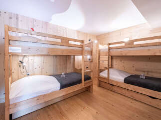 This cozy bedroom features two sets of wooden bunk beds, perfect for accommodating multiple guests or family members.
