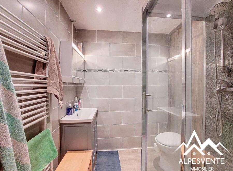 Discover this modern bathroom featuring a sleek shower enclosure and stylish tiled walls.