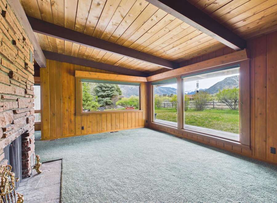 This stunning property boasts a warm and inviting interior with a cozy fireplace and expansive windows.