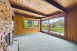 This stunning property boasts a warm and inviting interior with a cozy fireplace and expansive windows.