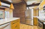 This charming kitchen boasts a rustic aesthetic with its exposed brick wall and warm wooden cabinetry.