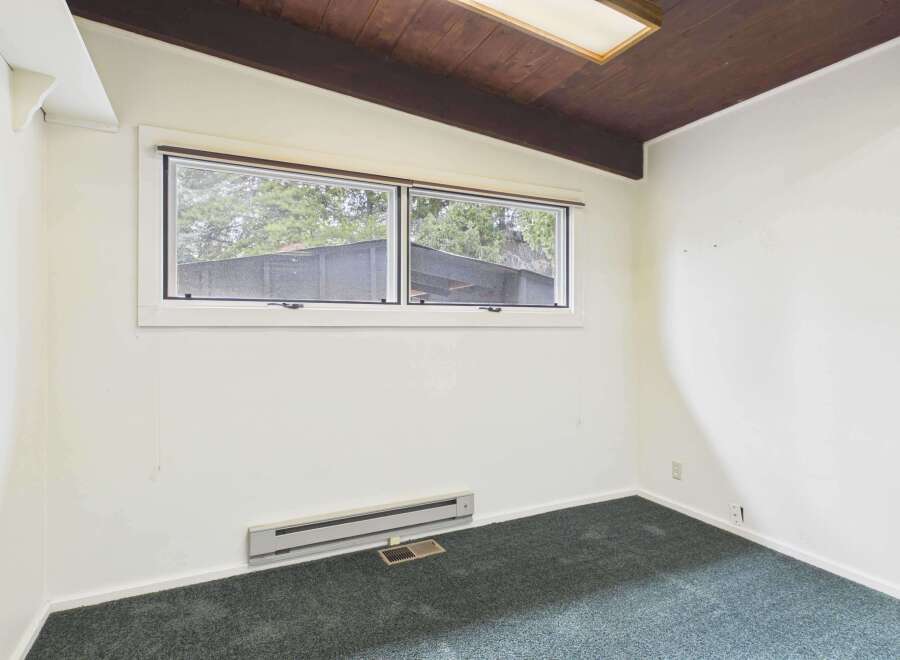 This inviting room features a large window that allows natural light to flood the space, creating a bright and airy atmosphere.