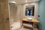 Step into luxury with this stunning bathroom! Featuring a modern design, this space boasts a sleek shower, a stylish sink, and a beautiful wooden door.