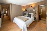 This cozy bedroom features a warm, inviting atmosphere with its wooden floors and neutral color palette.