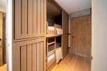 This cozy bunk room features custom-built bunk beds with integrated storage, perfect for maximizing space in a vacation home or rental property.