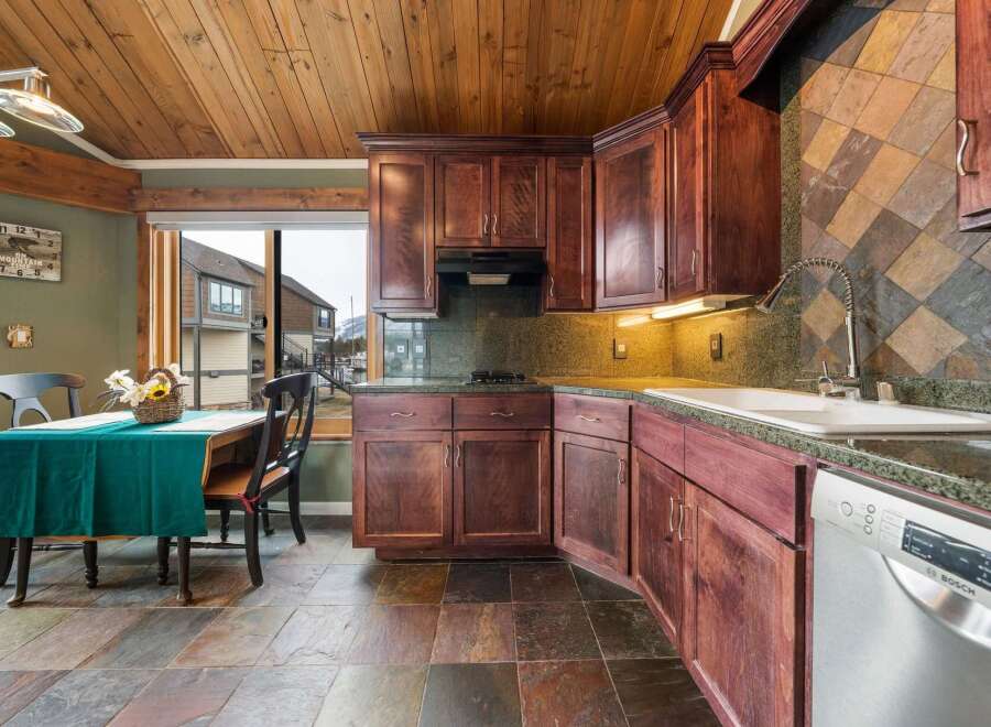 Step into this stunning kitchen, featuring rich, dark wood cabinetry and a unique tile backsplash.
