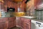 This stunning kitchen boasts rich, dark wood cabinetry and sleek granite countertops, creating a warm and inviting atmosphere.