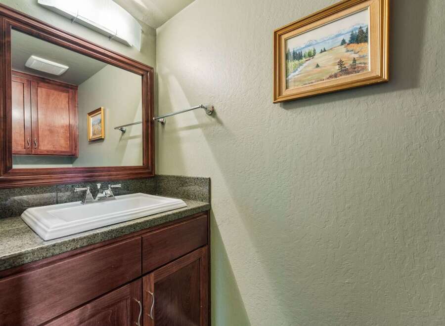 This bathroom features a stylish vanity with a dark wood finish and a granite countertop.