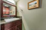 This bathroom features a stylish vanity with a dark wood finish and a granite countertop.