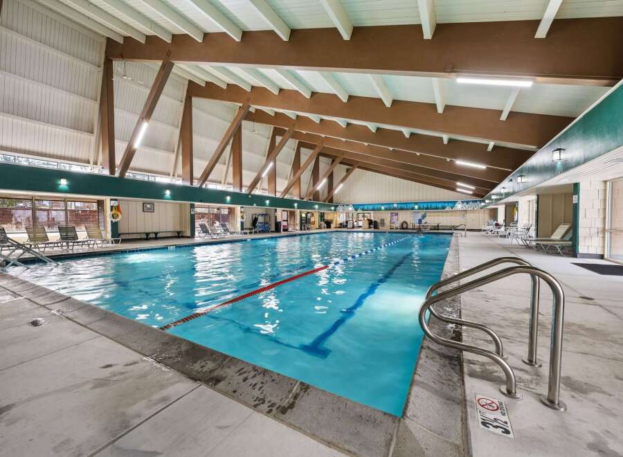 This indoor swimming pool offers a refreshing escape with its inviting blue waters and ample space for swimming and relaxation.