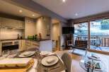 Experience luxury living in this stunning property, featuring a modern kitchen and a cozy dining area perfect for entertaining.