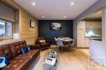 Experience luxury living in this stunning property, featuring a beautifully designed living area with a comfortable leather sofa and a stylish glass coffee table.