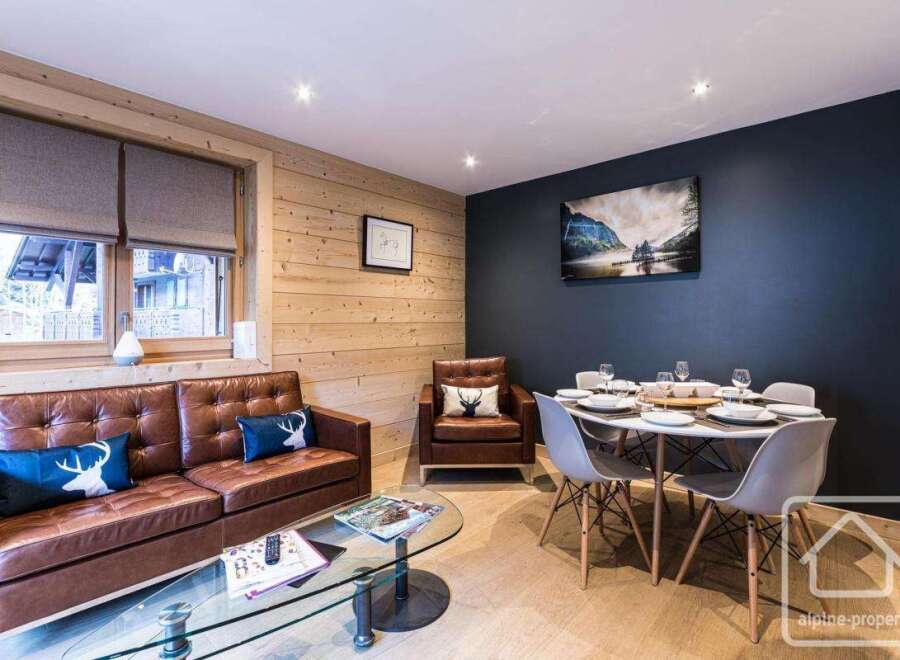 Experience luxury living in this stunning property, featuring a beautifully designed living area with a comfortable leather sofa and a stylish dining space.