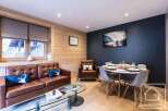 Experience luxury living in this stunning property, featuring a beautifully designed living area with a comfortable leather sofa and a stylish dining space.