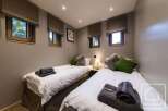 This cozy bedroom features two twin beds, perfect for a comfortable stay.