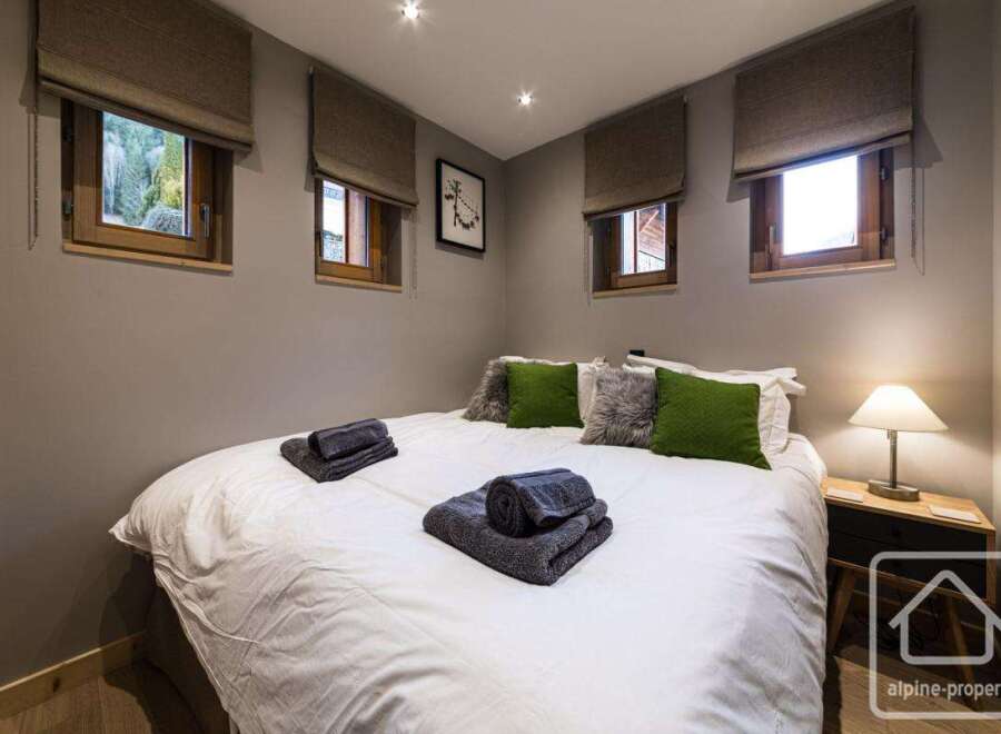 This cozy bedroom features a comfortable bed with fresh linens and plush pillows, perfect for a relaxing stay.